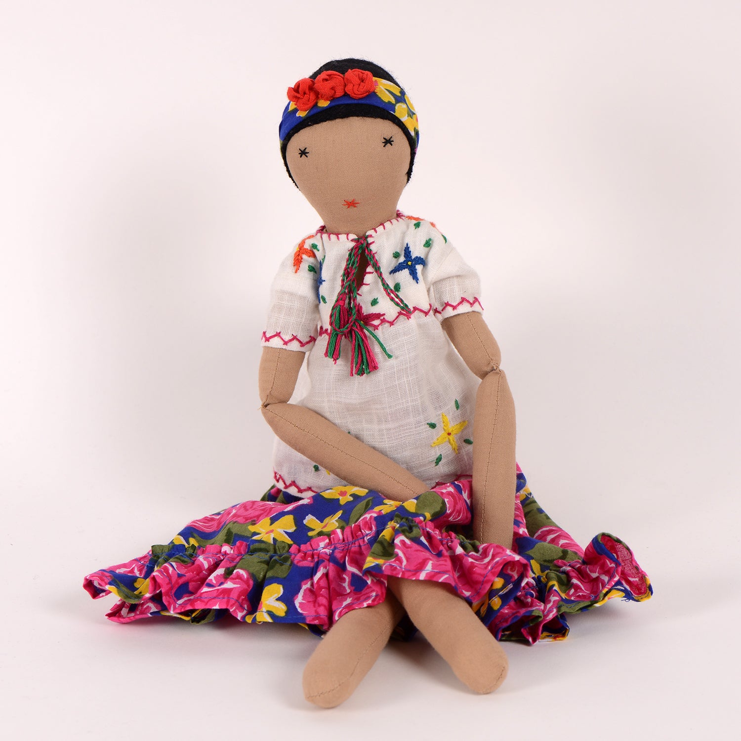 Frida, a handcrafted Afghan doll with vibrant floral patterns and intricate embroidery, symbolizing resilience and empowerment.